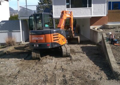 Excavator preparing driveway for new concrete driveway