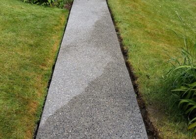 New thin, straight exposed aggregate concrete sidewalk