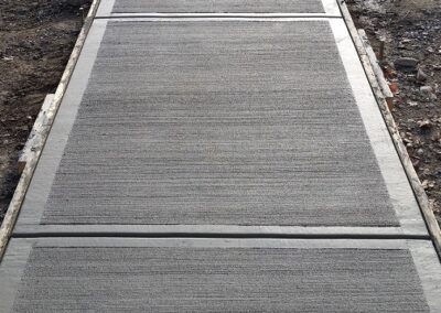 Concrete sidewalk at the top of a large concrete staircase