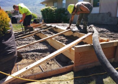 Pouring concrete for a raised patio, stairs, and sidewalk